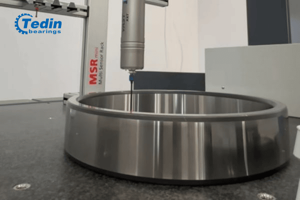Quality control engineer inspecting the dimensional accuracy of a P4 precision cylindrical roller bearing using a CMM.